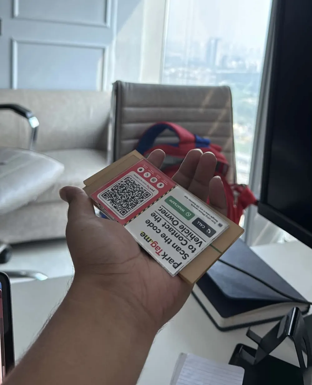 Actual clear laser-cut acrylic sheet with a ParkTag held in hand
